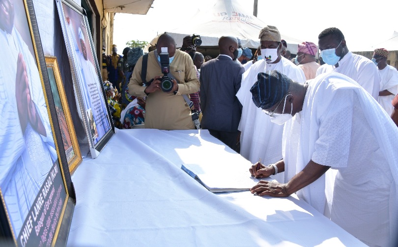 Lagos State Governor, Mr. Babajide Sanwo-Olu (right), signing the condolence register of Late Chief Lanre Razak during his visit to the family of the deceased on Sunday, August 16, 2020. With him are: Son of the deceased, Mr. Ibrahim Razak (middle) and Lagos Deputy Governor, Dr. Obafemi Hamzat (left).